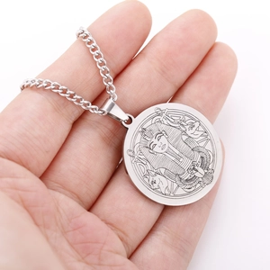 Macro view of silver Pharaoh Sphinx pendant on a stainless steel chain held by hand