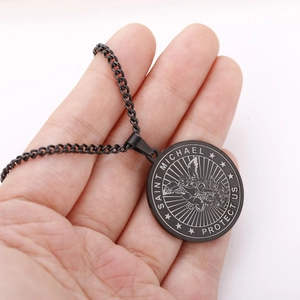 Close-up of black stainless steel St. Michael pendant with Saint Michael Protect Us engraving