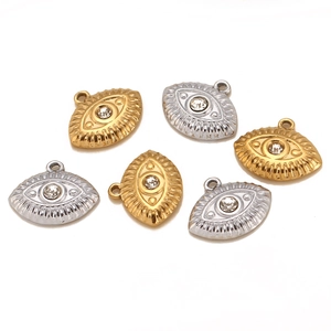 Detailed view of six gold and silver evil eye charms with central zircon and radial texture