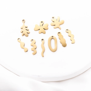 Detail of gold-plated stainless steel leaf and wave pendants for DIY jewelry making