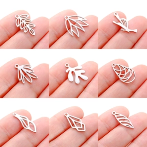 Set of 9 stainless steel hollow leaf and bird charms shown for size comparison
