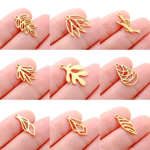 Detailed view of nine gold hollow leaf and bird pendants for DIY jewelry crafting