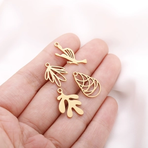 Detailed view of hollow spiral leaf and bird metal pendants for DIY jewelry making