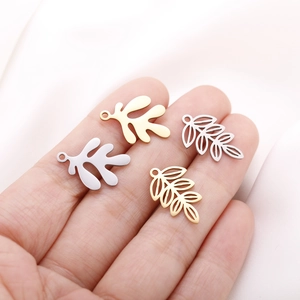 Detailed view of hollow and solid leaf charms in gold and silver for DIY jewelry