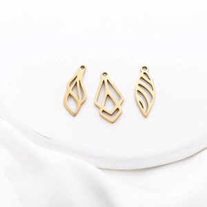 Close-up of golden stainless steel hollow leaf and geometric pendants for DIY jewelry