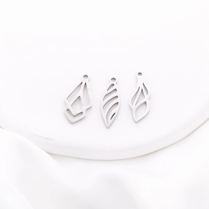Macro view of silver hollowed leaf and geometric stainless steel jewelry pendants
