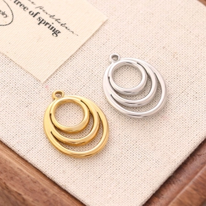 Detailed view of layered circular geometric pendants in gold and silver steel finish