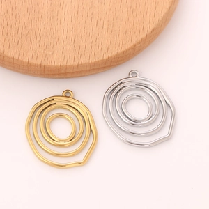 Macro detail of concentric circular spiral pendants in gold and silver finishes