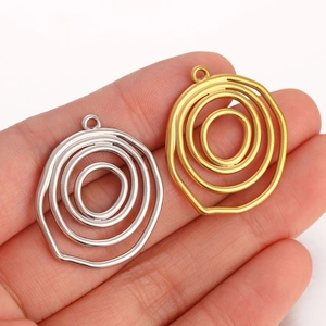 Handheld view of gold and silver spiral hollow circle stainless steel DIY jewelry pendants