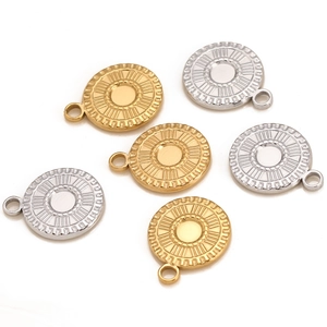Macro view of gold and silver sunburst engraved stainless steel round charms for DIY jewelry
