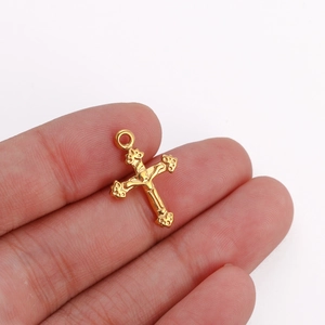 Primer plano detallado de un colgante de cruz dorada con un crucifijo de Jesús en relieve