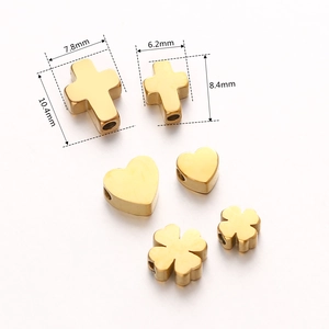 Detailed gold stainless steel beads in heart, clover, and cross shapes for DIY jewelry