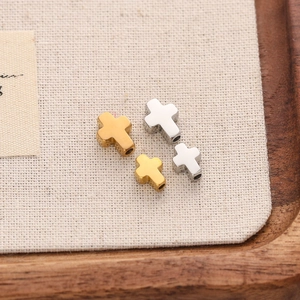 Detailed view of cross-shaped stainless steel DIY beads with horizontal side holes