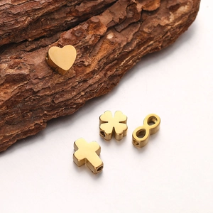Detailed view of golden heart and clover charms on a natural bark decorative background