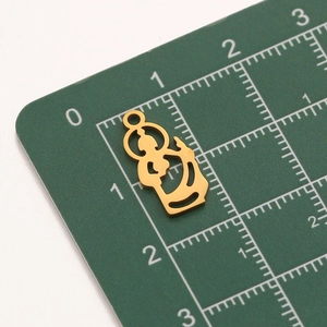 Detailed close-up of a 22mm gold-plated stainless steel Jesus pendant charm on scale