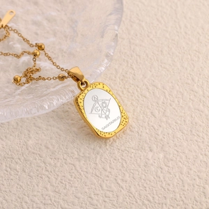 Goldene Schütze Halskette mit rechteckigem graviertem Anhänger auf hellem Grund