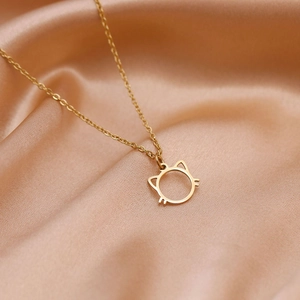 Collier avec pendentif chat doré élégant sur tissu de soie champagne luxueux