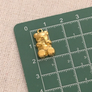 Macro shot of 2cm polished golden stainless steel teddy bear pendant for DIY jewelry