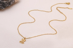 Vue détaillée du collier en acier doré avec pendentif ours et poinçon S.STEEL