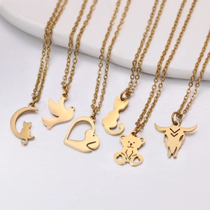 Sechs minimalistische goldene Edelstahl-Tierketten auf einem weißen Keramiktablett