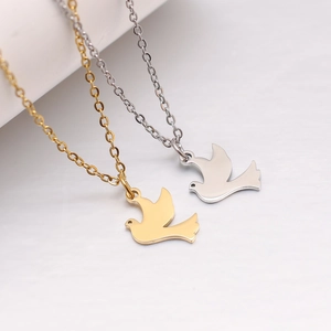 Detailaufnahme der Vogel-Anhänger-Halsketten aus poliertem Gold- und Silber-Edelstahl
