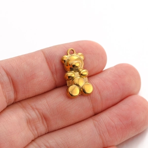 Detailed macro view of a 3D teddy bear pendant in polished gold stainless steel
