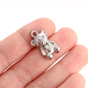 Detailed view of a mini 3D teddy bear pendant in silver steel with a tiny neck bow