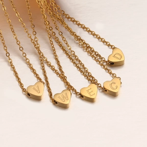 Detalle de colgantes de corazón dorados con letras V, W, E, C, D en cadena cruzada