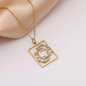 Detail van gouden roestvrijstalen Vissen sterrenbeeld hanger aan ketting op zijde