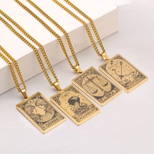 Detailed close-up of gold-plated zodiac tarot necklaces showing Gemini and Libra engravings