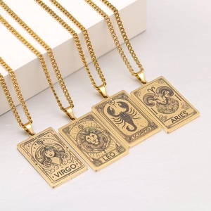 Detail of four gold zodiac tarot necklaces with engraved signs on rectangular pendants
