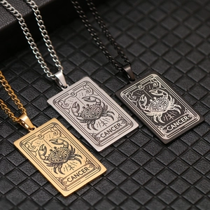 Detailed engraving of Cancer zodiac signs on gold, silver, and black metal tarot pendants