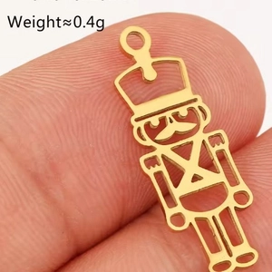 Detailed close-up of a tiny gold Nutcracker pendant weighing 0.4g with intricate cutout