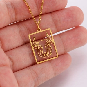 Detailweergave van de holle gouden Stier-ketting met ossenkop-hanger aan kruisketting