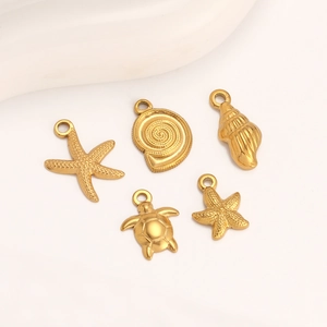 Detailed macro view of 14K gold-plated starfish, shell, and turtle jewelry pendants