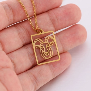 Gedetailleerde macro-opname van een gouden Ram-sterrenbeeld hanger aan een edelstalen ketting