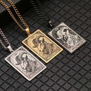 Detail of Capricorn zodiac pendants in gold, silver, and black on a textured black pad