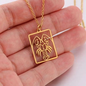 Macro-opname van een gouden rechthoekige hanger met een gedetailleerd kreeft-ontwerp