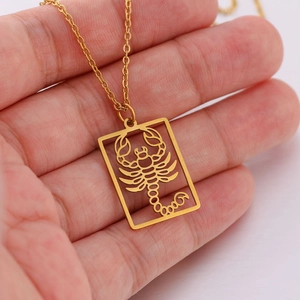 Detailopname van een gouden Schorpioen sterrenbeeld ketting met hol rechthoekig hanger