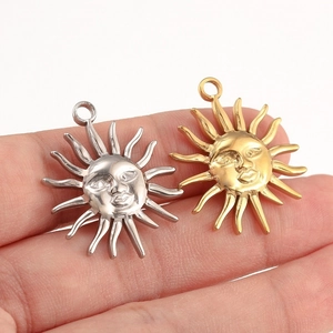 Pendentif soleil en acier inoxydable poli couleur or et argent sur une main