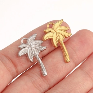 Détail macro de pendentifs cocotier en métal doré et argenté pour bijoux DIY