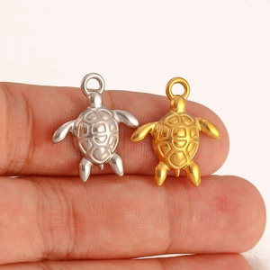 Dettaglio dei ciondoli a forma di tartaruga in argento e oro per gioielli fai-da-te