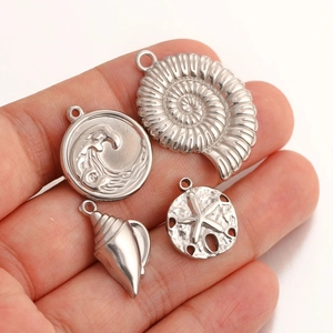 Detailed macro view of silver ocean-themed pendants including seashell and starfish shapes