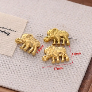 Macro shot of three golden elephant metal beads for DIY jewelry with size dimensions
