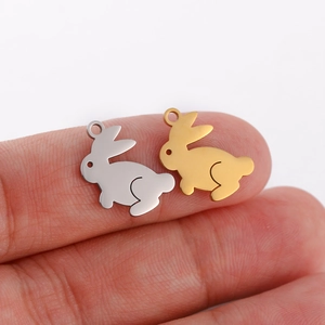 Detailed view of gold and silver rabbit charms for DIY jewelry making on hand