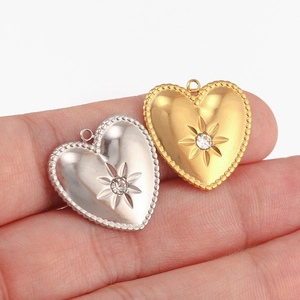 Vue macro de pendentifs en forme de cœur en acier inoxydable avec motif soleil et zircon