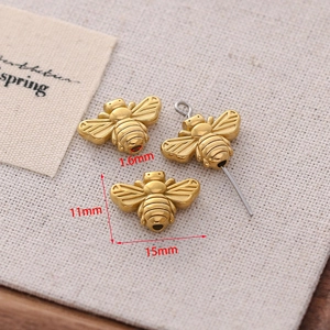 Detailed view of small golden bee charms for DIY jewelry with size measurements