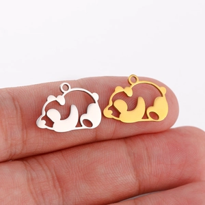 Macro shot of silver and gold panda charms on fingers showing precise laser-cut details