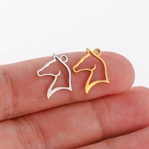 Macro shot of two hollow horse head pendants in gold and silver finish for DIY jewelry