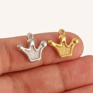 Macro detail of gold and silver crown charms showing polished and frosted finishes